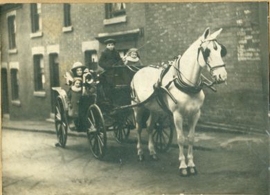 Victorian family in brougham carriage pulled by a white horse