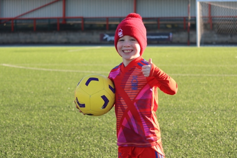 Child smiling holding a football