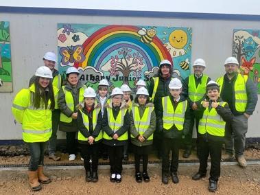 Albany Junior School children and teachers standing in front of their artwork at the new Stapleford Community Pavilion